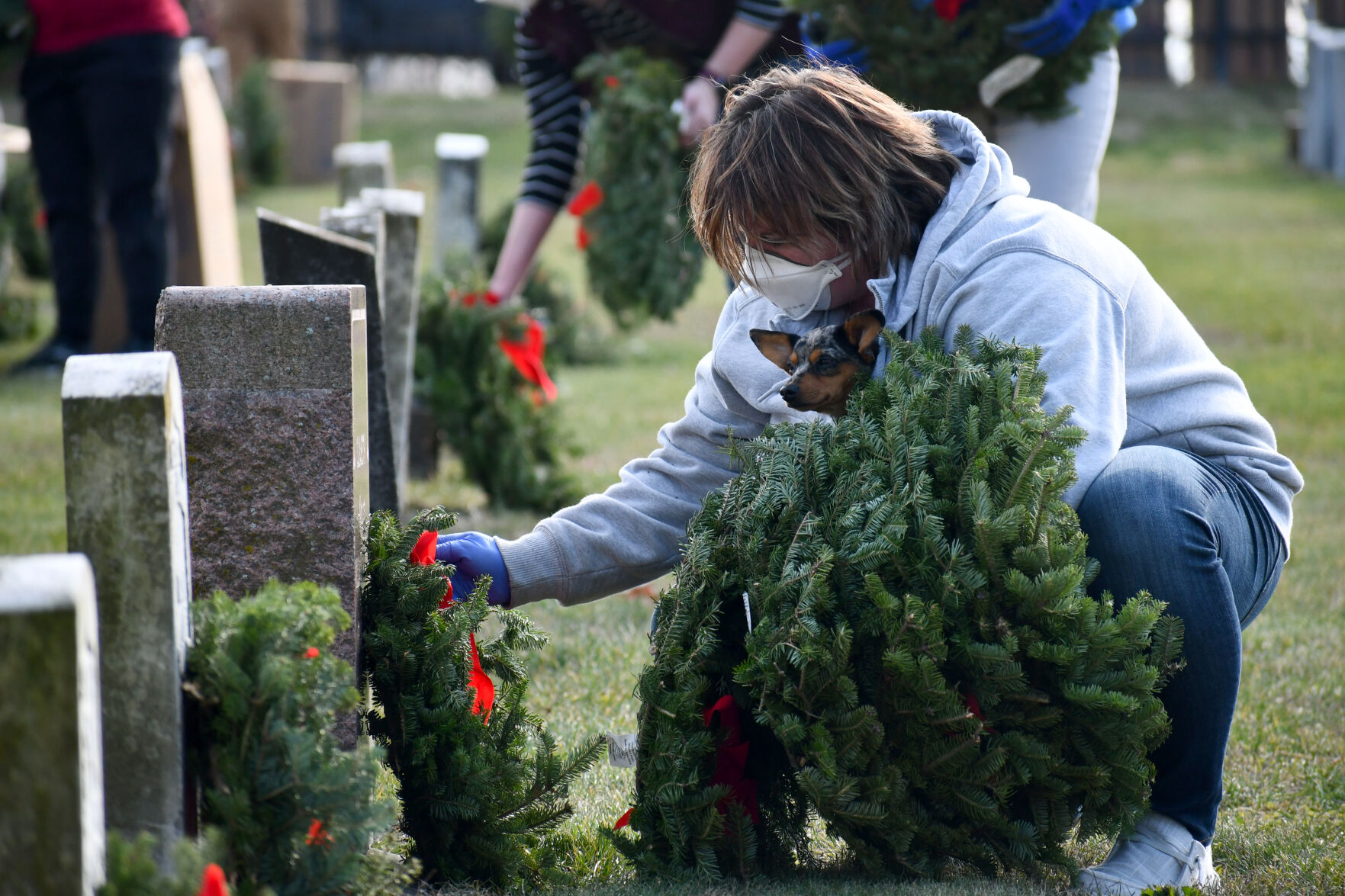 Emily West adjusts a wreath's ribbon